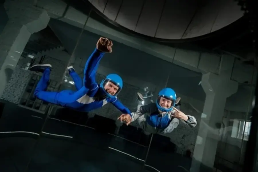 A man and a woman enjoy flying together in a wind tunnel. Free fall simulator